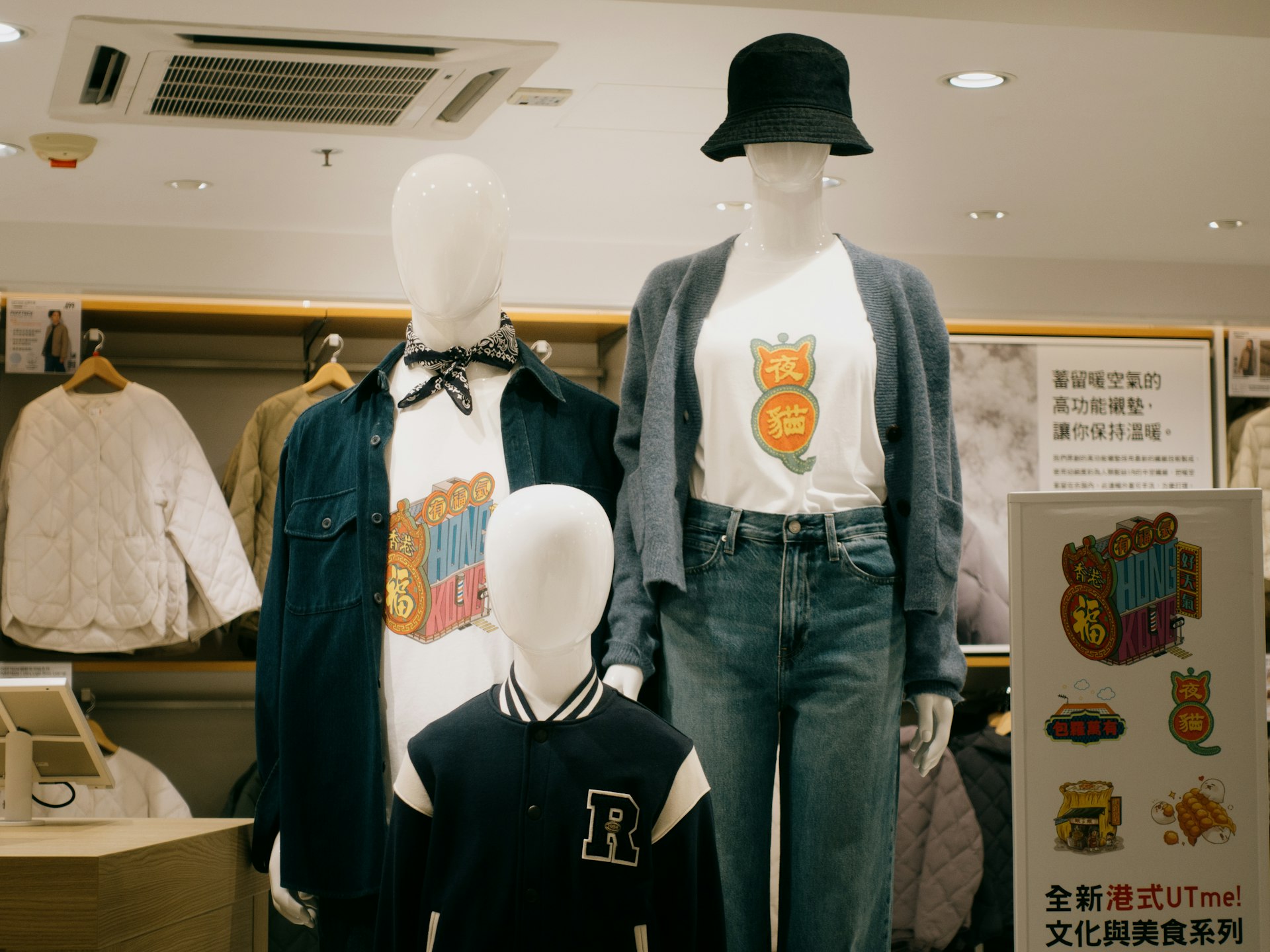 Two mannequins wearing shirts and hats in a store